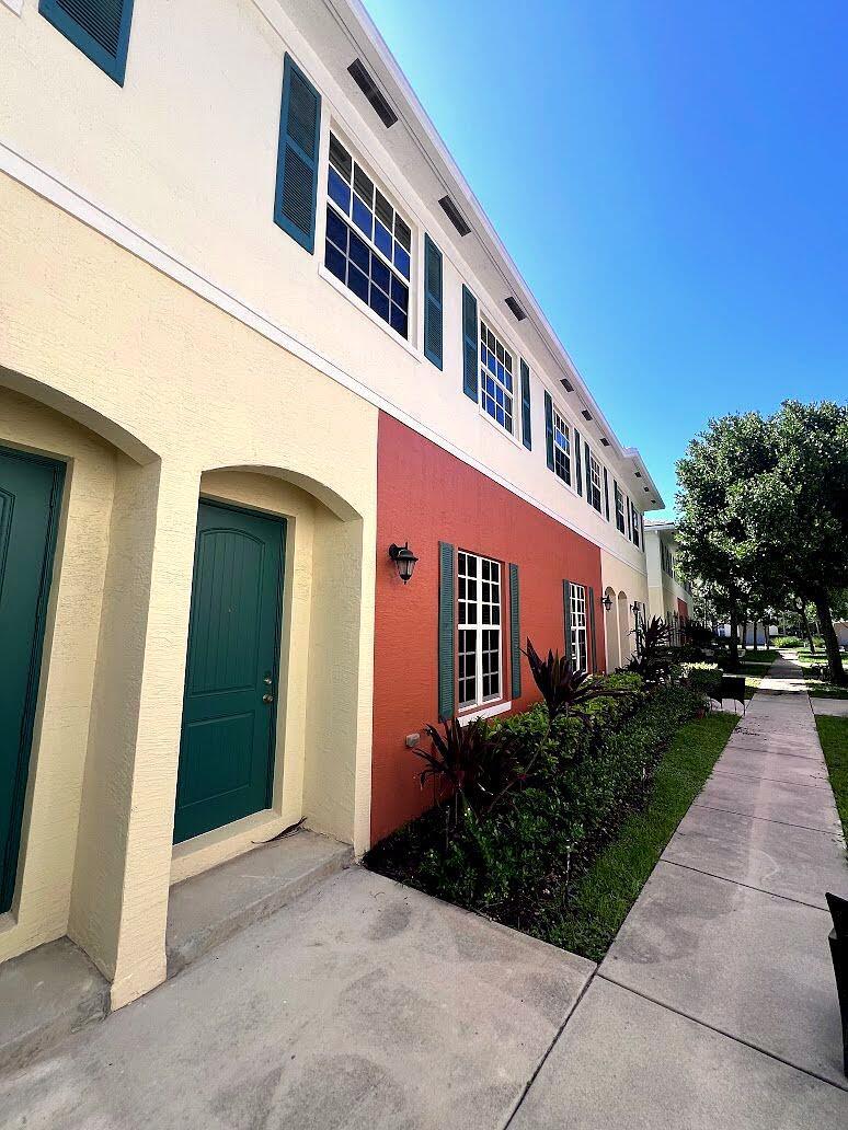 A multi-story townhouse exterior with a red and beige facade, green shutters, and a sidewalk — 726 SW 1st Way, Pompano Beach FL 33060, POMPANO BEACH, FL