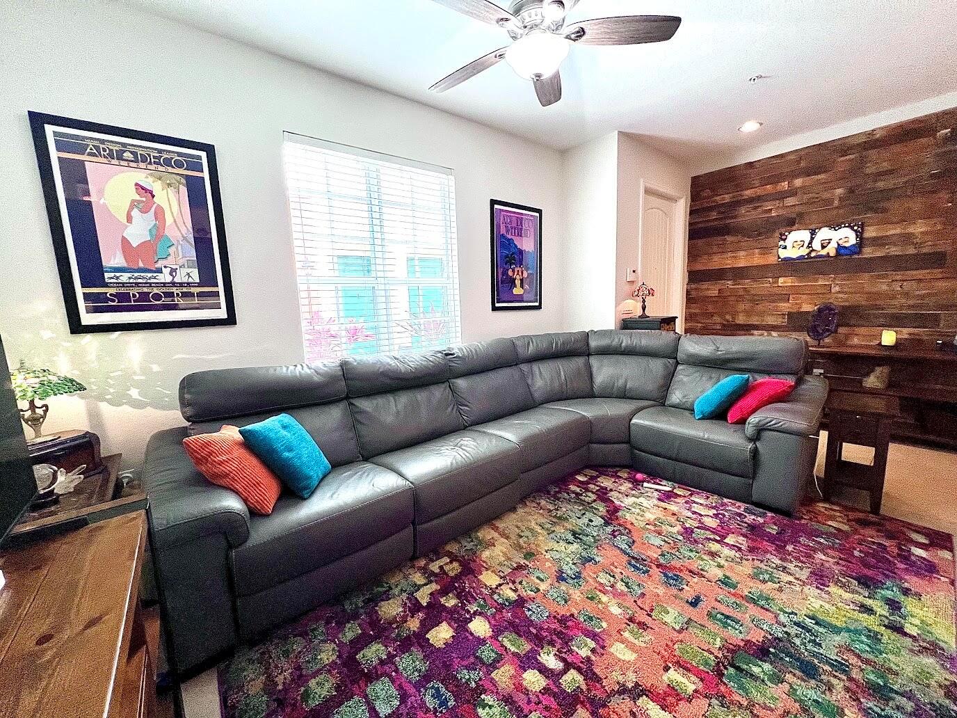 A living room features a large gray sectional sofa, a colorful rug, and wood-paneled wall — 726 SW 1st Way, Pompano Beach FL 33060, POMPANO BEACH, FL