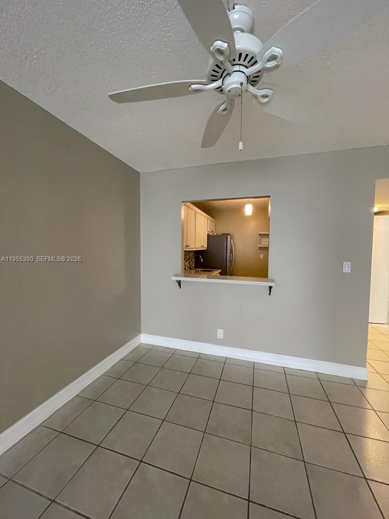 A dining area with tile floors, a ceiling fan, and a kitchen pass-through window — 1000 Parkview Dr # 1016, Hallandale Beach FL 33009, HALLANDALE BEACH, FL