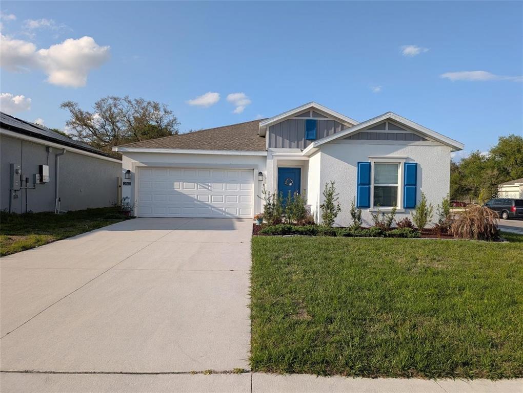A single-story house with a white stucco exterior, blue shutters, and a two-car garage — 2860 BIG SUR ROAD, DAVENPORT, FL