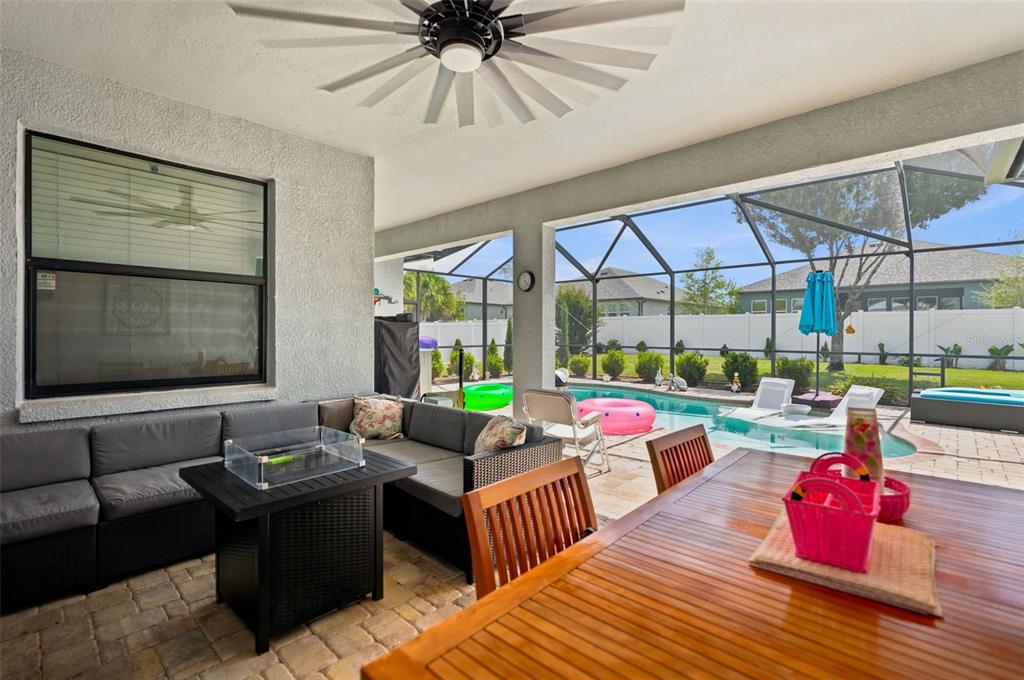 A covered patio features a sectional sofa, dining table, and a screened-in pool area — 652 TIERRA DRIVE, SPRING HILL, FL