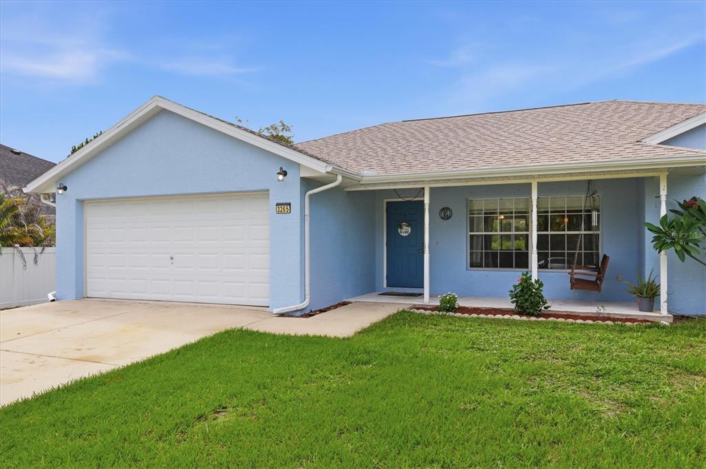 A living room with tile floors, a dark sectional sofa, and an open kitchen — 3265 QUARTER STREET, NORTH PORT, FL
