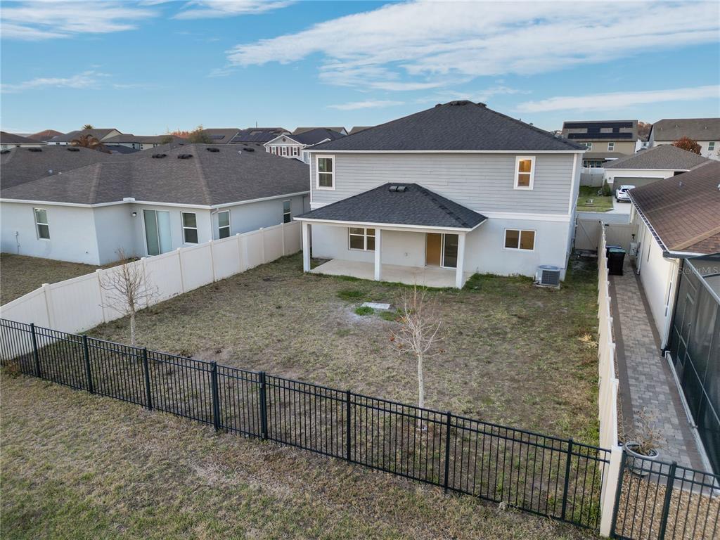 An aerial view of a two-story house with a fenced backyard and covered patio — 13916 RUSHING CREEK RUN, ORLANDO, FL