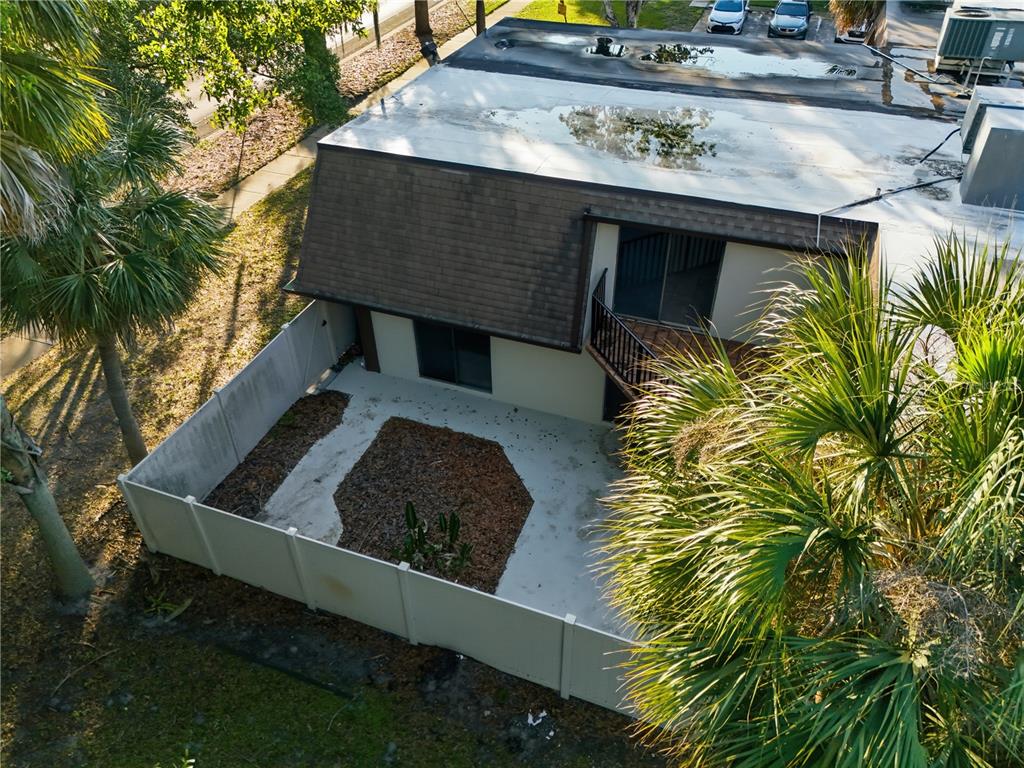 An aerial view of a two-story building with a fenced patio and palm trees — 4026 SHANNON BROWN DRIVE, ORLANDO, FL