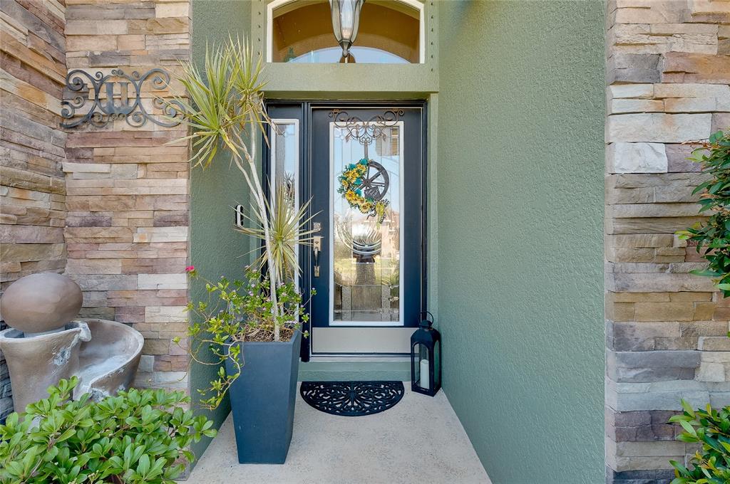 A front entryway features a dark door with a glass insert, stone siding, and a planter — 7830 113TH AVENUE E, PARRISH, FL