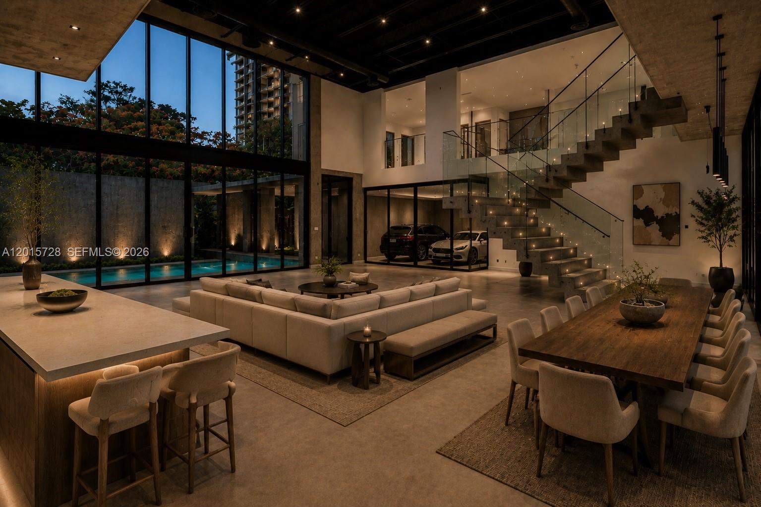 A modern open-concept living area features a glass-enclosed garage, floating staircase, and indoor pool view — 221 SW 25th Rd, Miami FL 33129, MIAMI, FL