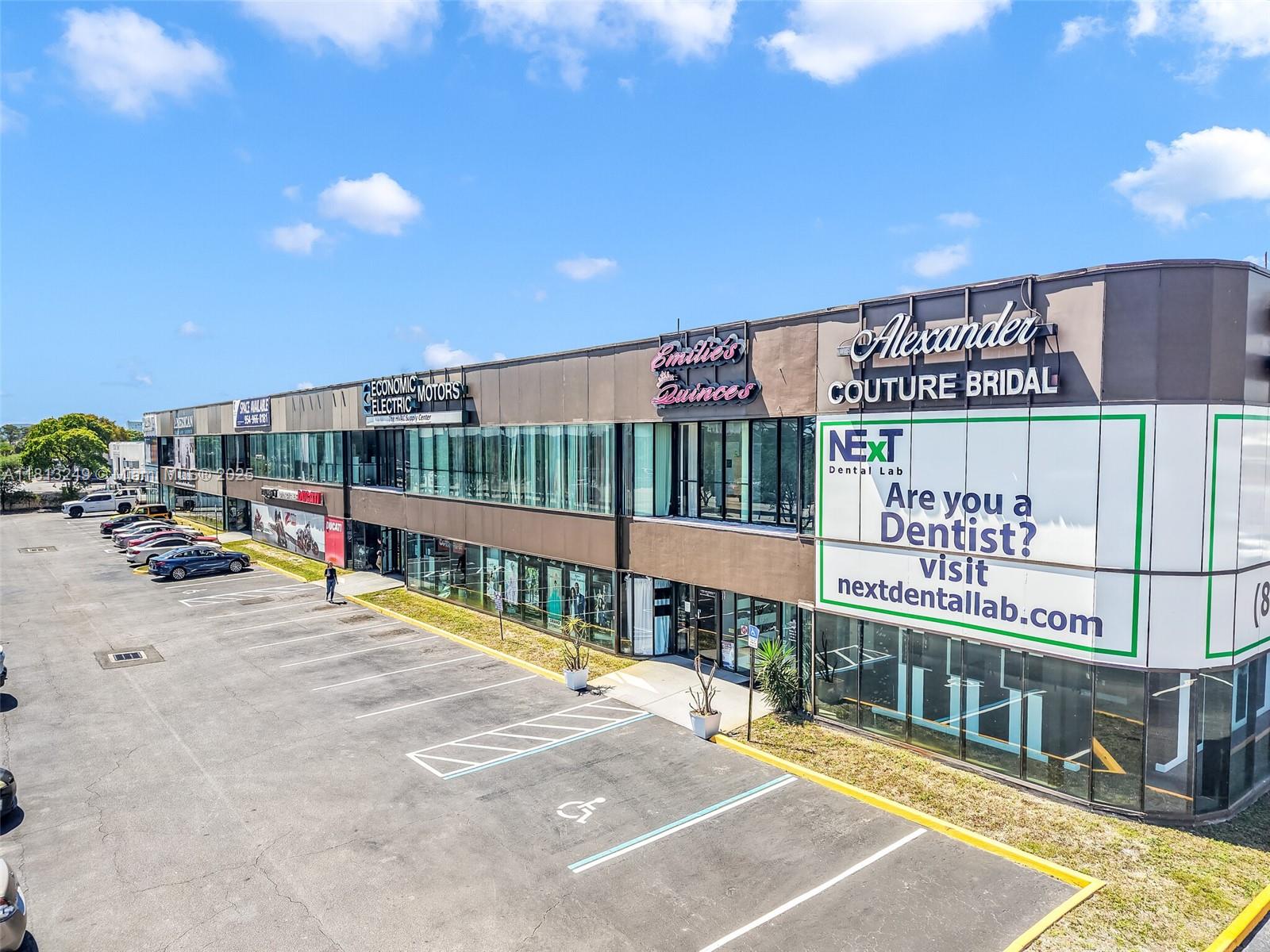 An exterior view of a two-story commercial strip mall with a parking lot in front — 820 SW 12th Ave # 7B, Pompano Beach FL 33069, POMPANO BEACH, FL