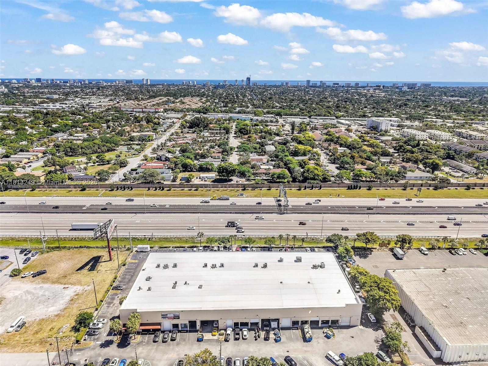 An aerial view shows a large warehouse building with a parking lot next to a highway — 820 SW 12th Ave # 7B, Pompano Beach FL 33069, POMPANO BEACH, FL