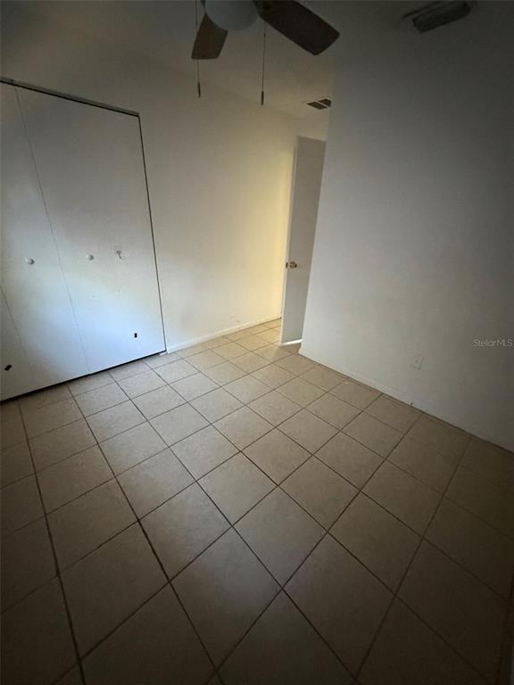 A small, empty room features white walls, a white closet, and light-colored tile flooring — 6458 79TH AVENUE N, PINELLAS PARK, FL