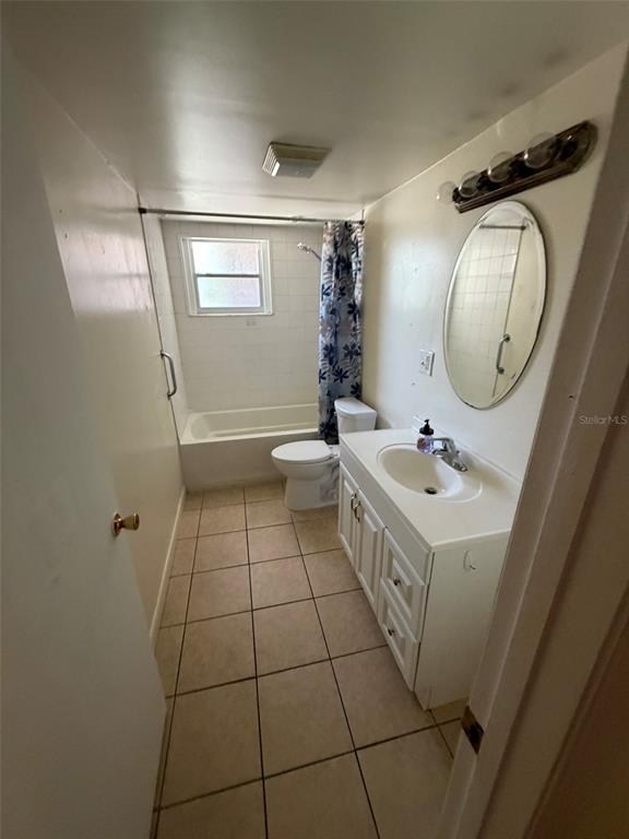 A bathroom features a white vanity, a toilet, and a shower-tub combination with tile flooring — 6458 79TH AVENUE N, PINELLAS PARK, FL