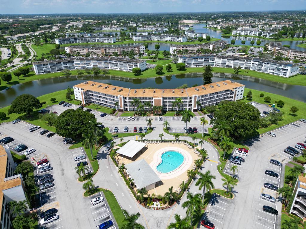 An aerial view of a multi-story apartment complex with a swimming pool and parking lots — 2044 Hythe C, Boca Raton FL 33434, BOCA RATON, FL