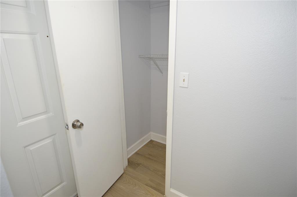 A small closet with a wire shelf is visible next to a white door — 8758 MALLARD RESERVE DRIVE UNIT 101, TAMPA, FL