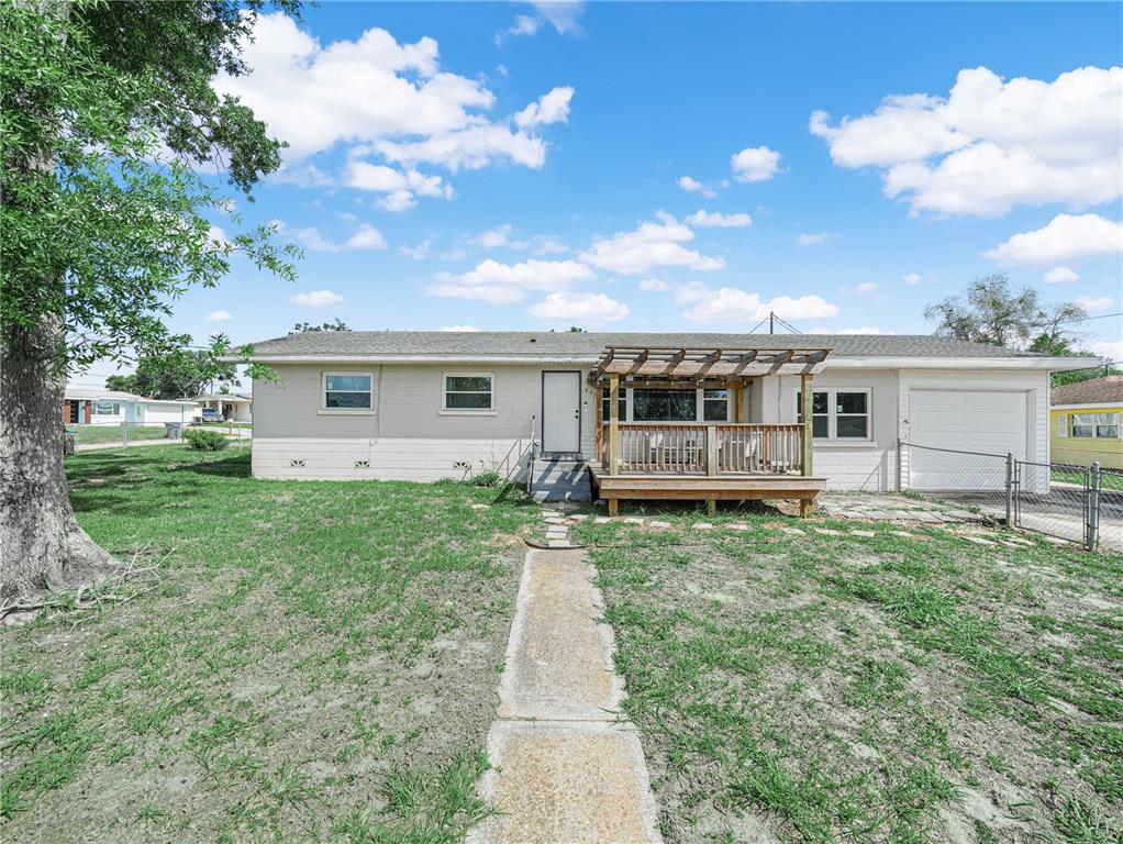 A single-story house with a wooden deck, pergola, and attached garage sits on a lawn — 231 RIDGE MANOR DRIVE, LAKE WALES, FL