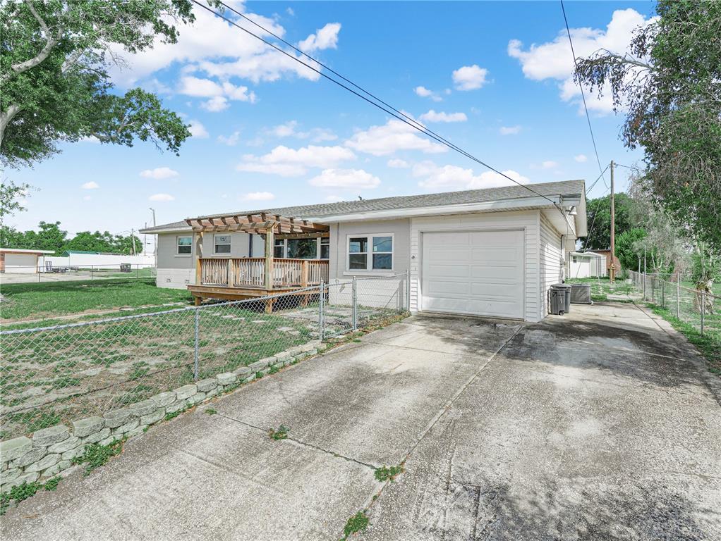 The exterior of a single-story house features a wooden deck, a garage, and a driveway — 231 RIDGE MANOR DRIVE, LAKE WALES, FL