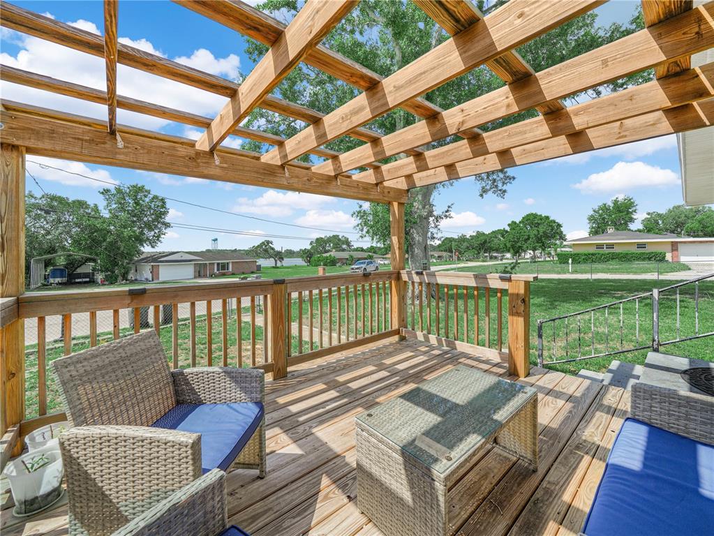 A wooden deck features a pergola, wicker furniture, and a view of a neighborhood — 231 RIDGE MANOR DRIVE, LAKE WALES, FL