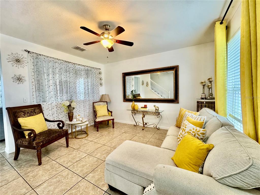 A two-story suburban house with a tan exterior, a two-car garage, and a concrete driveway — 1868 MONTE CRISTO LANE, KISSIMMEE, FL