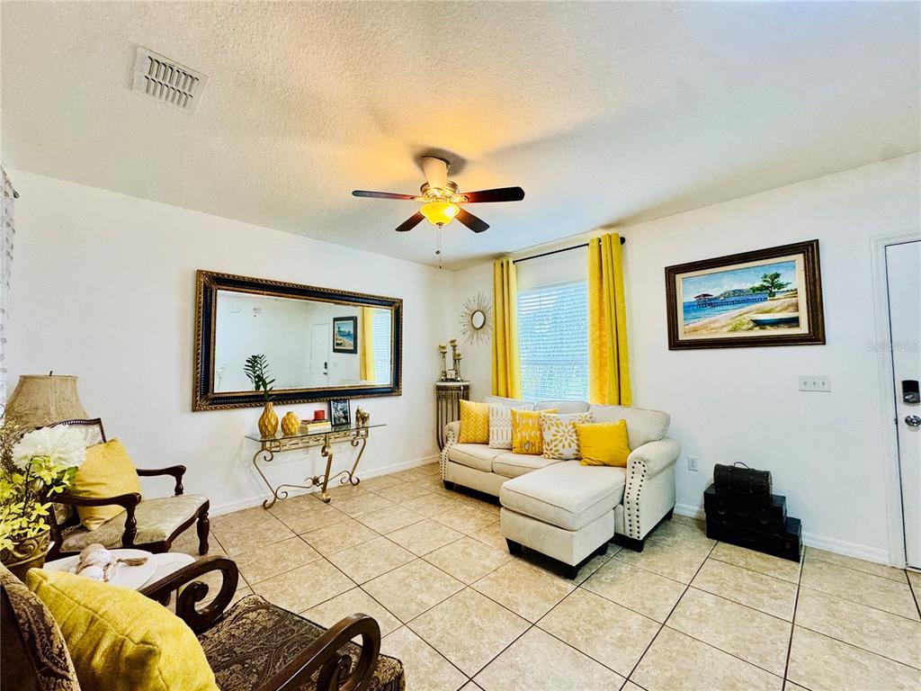 A two-story suburban house with a tan stucco exterior, a two-car garage, and a driveway — 1868 MONTE CRISTO LANE, KISSIMMEE, FL