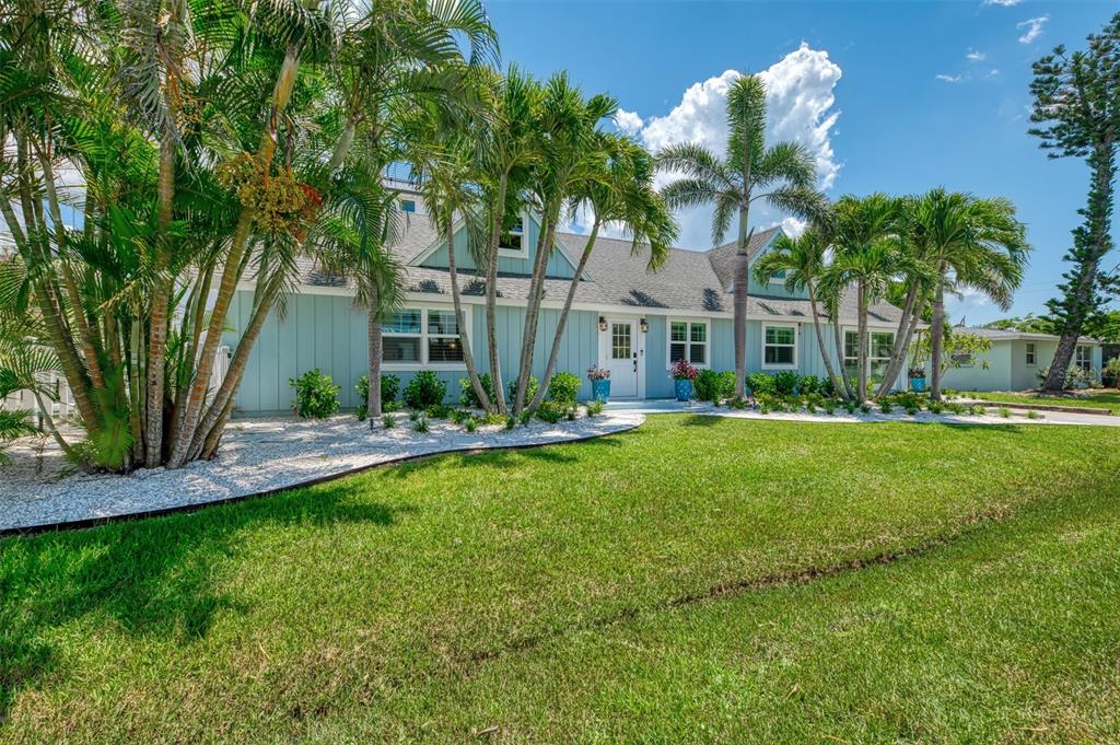 A light blue house with a white door and palm trees in the front yard — 1100 POINT OF ROCKS ROAD, SARASOTA, FL