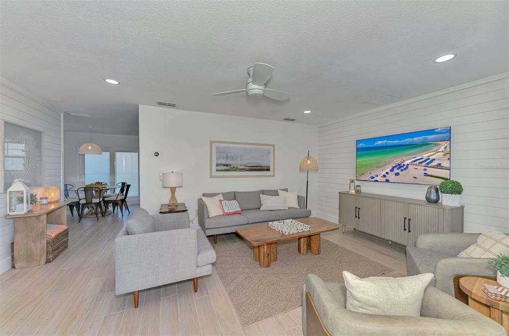 A living room features a grey sofa, armchairs, a wooden coffee table, and shiplap walls — 1100 POINT OF ROCKS ROAD, SARASOTA, FL