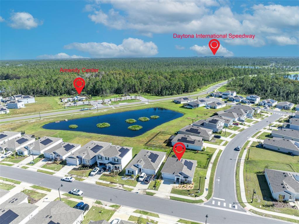 An aerial view shows a suburban neighborhood with houses, a pond, and nearby landmarks — 1156 SAND TRAP COURT, DAYTONA BEACH, FL
