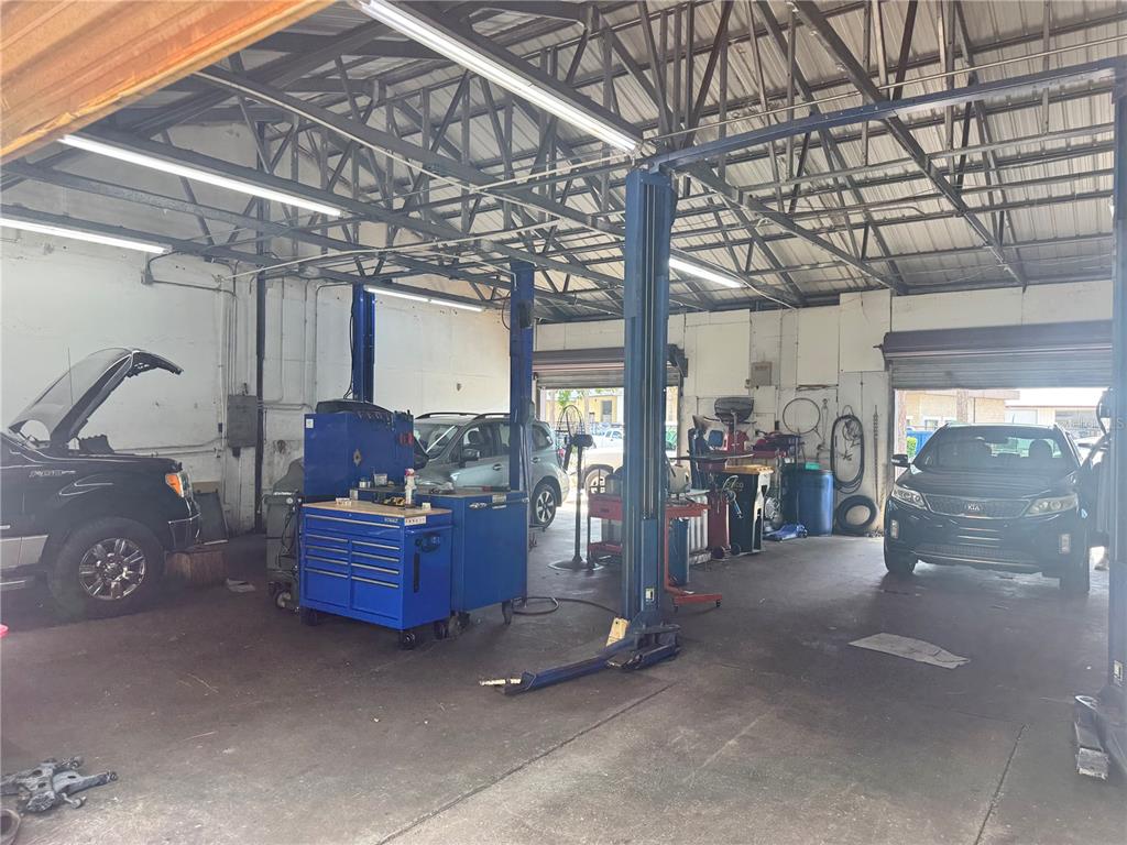 An auto repair shop interior features a vehicle lift, a blue tool chest, and cars — 6 MARKET PLACE COURT, PALM COAST, FL