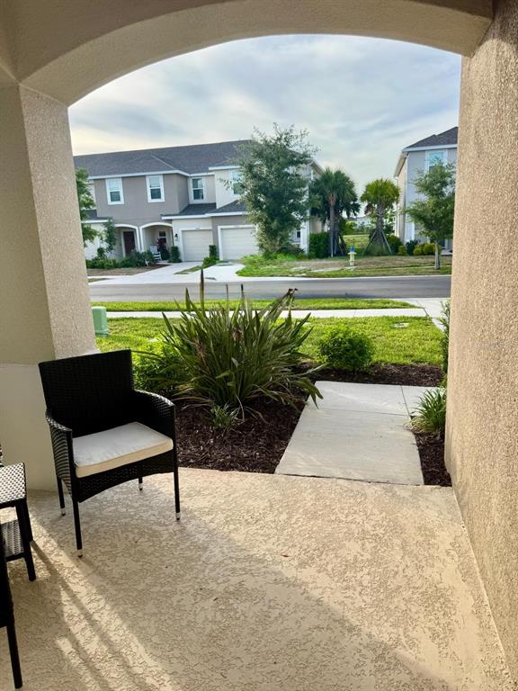 A view from a covered porch looking out toward a street and neighboring suburban houses — 5715 ARCHIPELAGO STREET, NOKOMIS, FL