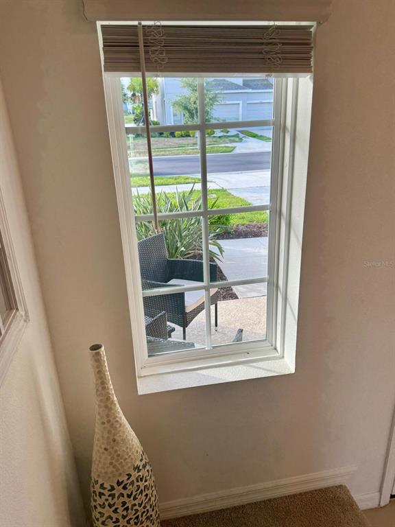 A window with a blind looks out onto a patio and a suburban street — 5715 ARCHIPELAGO STREET, NOKOMIS, FL