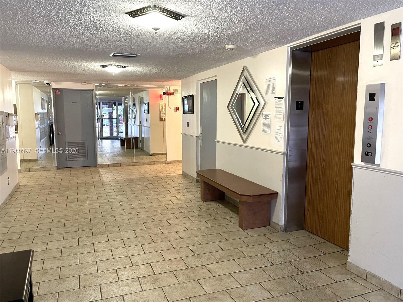 An apartment building lobby features a wall of mailboxes, tiled floors, and a seating area — 2061 NW 47th Ter # 306, Lauderhill FL 33313, LAUDERHILL, FL