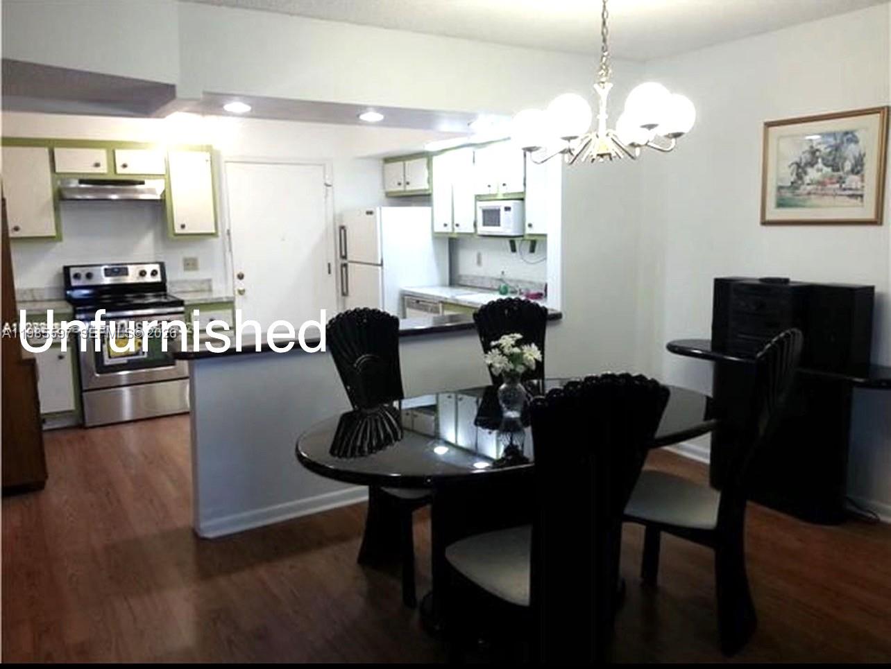 A tiled apartment building lobby features an elevator, a wooden bench, and a diamond-shaped mirror — 2061 NW 47th Ter # 306, Lauderhill FL 33313, LAUDERHILL, FL