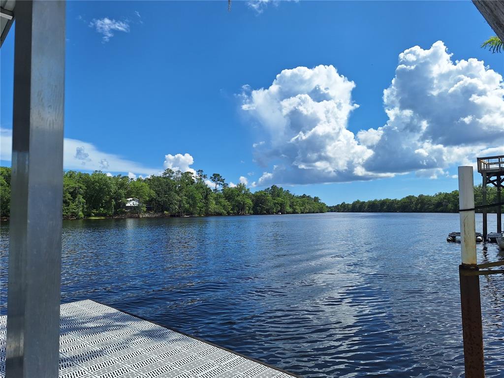 A view of a river from a wooden dock under a bright blue sky — 8213 RIVERVIEW ROAD, FANNING SPRINGS, FL