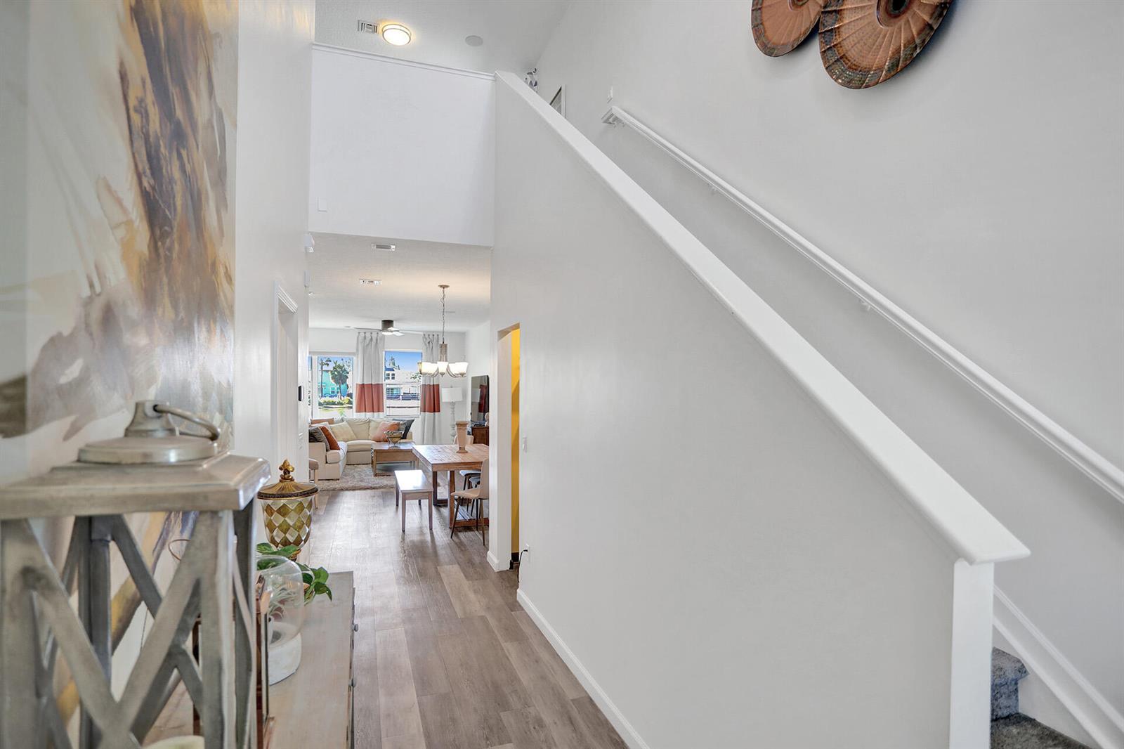 A hallway with wood-look flooring leads to an open-concept dining and living area — 1905 Vernon Street, FL 33460, FL