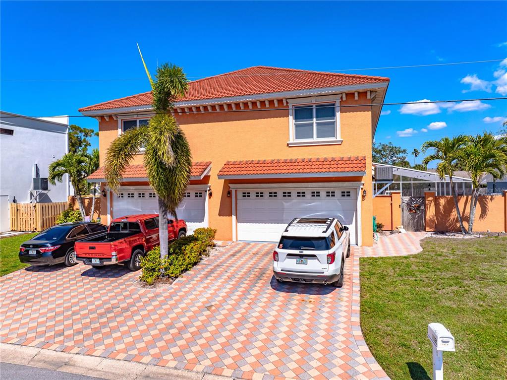 A two-story orange house with a tiled roof and a paved driveway featuring three parked vehicles — 2119 & 2125 MONTCLAIR DRIVE UNIT 1 & 2, SARASOTA, FL