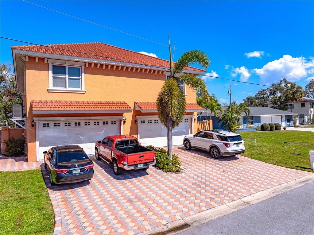 A two-story orange house with a tiled roof and a paved driveway featuring three cars — 2119 & 2125 MONTCLAIR DRIVE UNIT 1 & 2, SARASOTA, FL