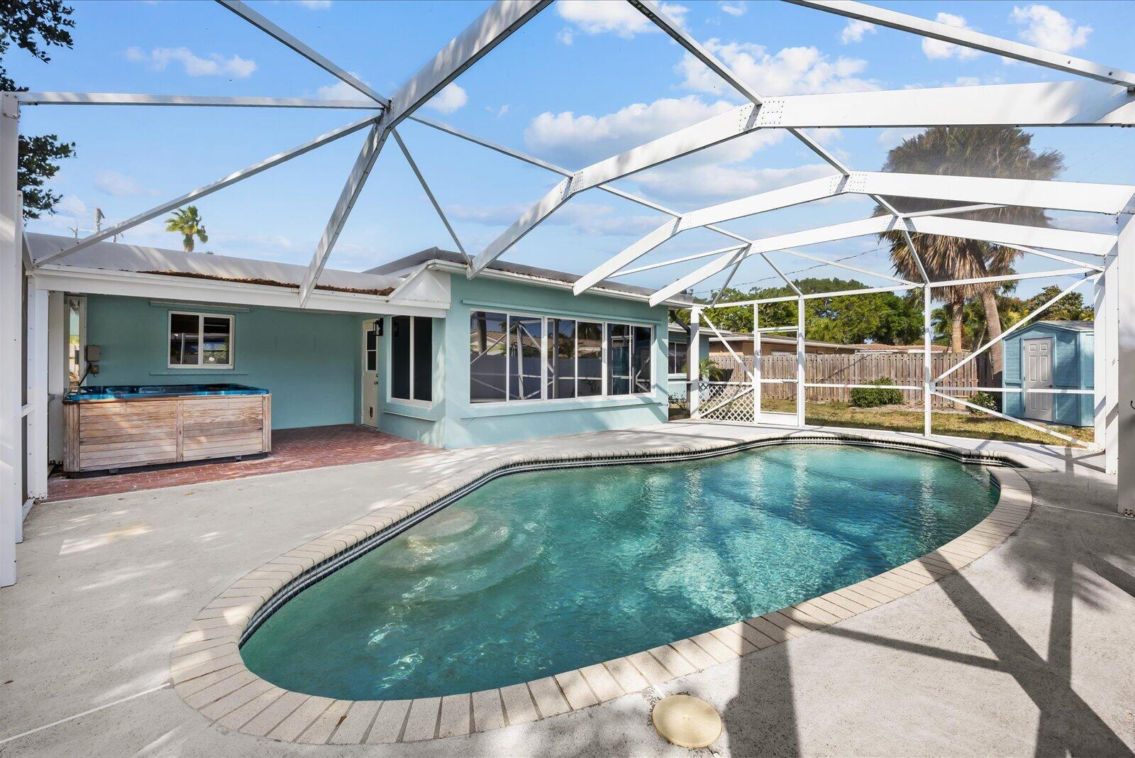 A backyard pool and hot tub enclosed by a screened lanai next to a house — 800 SE 13th Court, Deerfield Beach FL 33441, DEERFIELD BEACH, FL