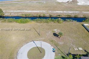 An aerial view shows a vacant lot with a circular cul-de-sac and a canal — 3923 NW 33RD PL, Cape Coral FL 33993, CAPE CORAL, FL