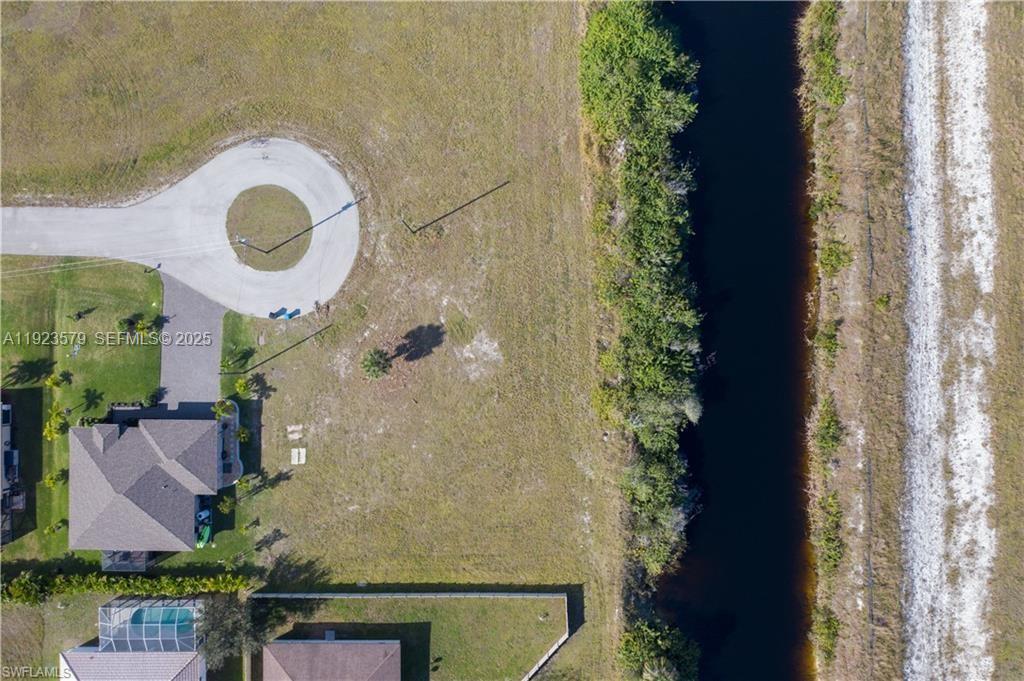 An aerial view shows a house with a pool next to a canal and cul-de-sac — 3923 NW 33RD PL, Cape Coral FL 33993, CAPE CORAL, FL
