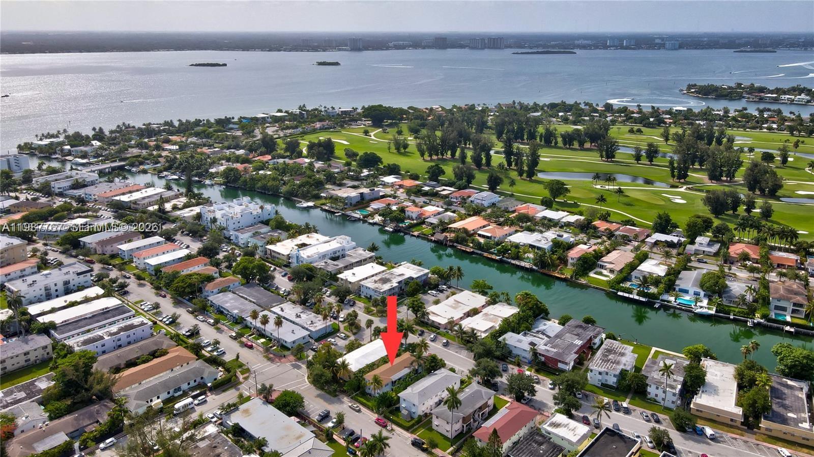 An aerial view shows a residential neighborhood with a canal and a golf course nearby — 1791 Marseille Dr, Miami Beach FL 33141, MIAMI BEACH, FL