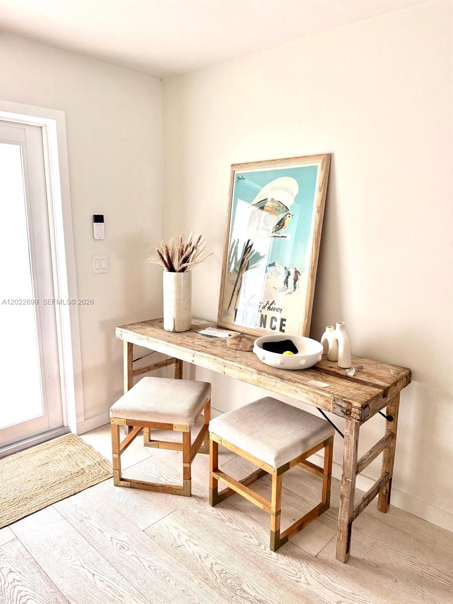 A rustic wooden console table with two upholstered stools sits against a light-colored wall — 8300 Hawthorne Ave, Miami Beach FL 33141, MIAMI BEACH, FL