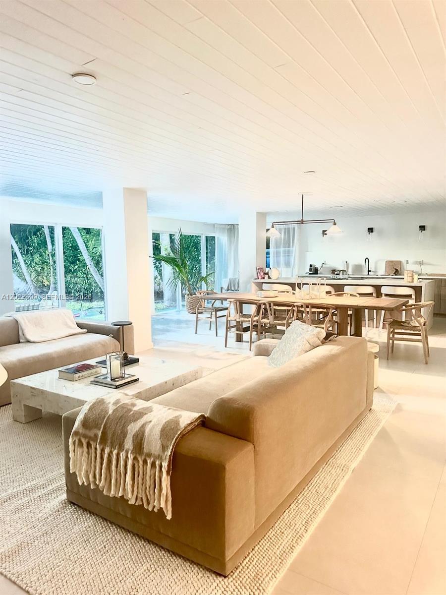 An open-concept living and dining area features white plank ceilings and light tile floors — 8300 Hawthorne Ave, Miami Beach FL 33141, MIAMI BEACH, FL