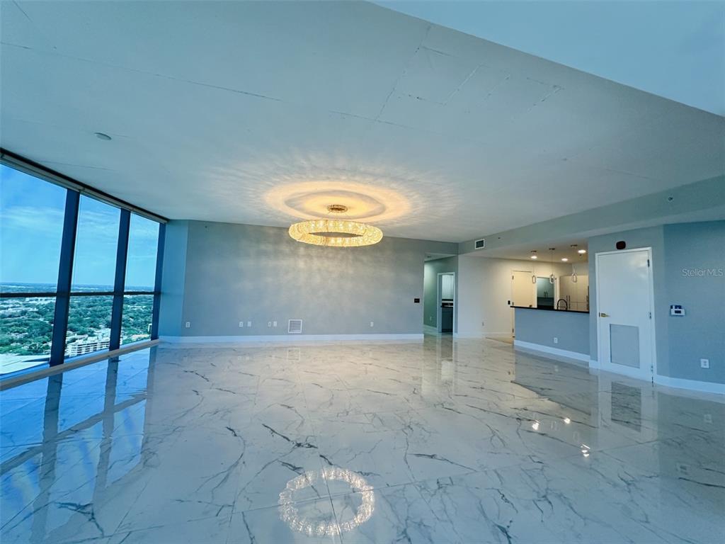 A spacious room with white marble floors, a large chandelier, and floor-to-ceiling windows — 111-3 WASHINGTON STREET, ORLANDO, FL