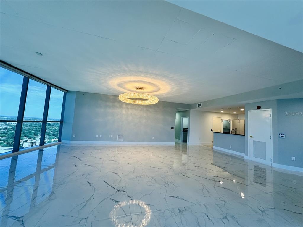 A spacious room with marble floors, a large crystal chandelier, and floor-to-ceiling windows — 111-3 WASHINGTON STREET, ORLANDO, FL