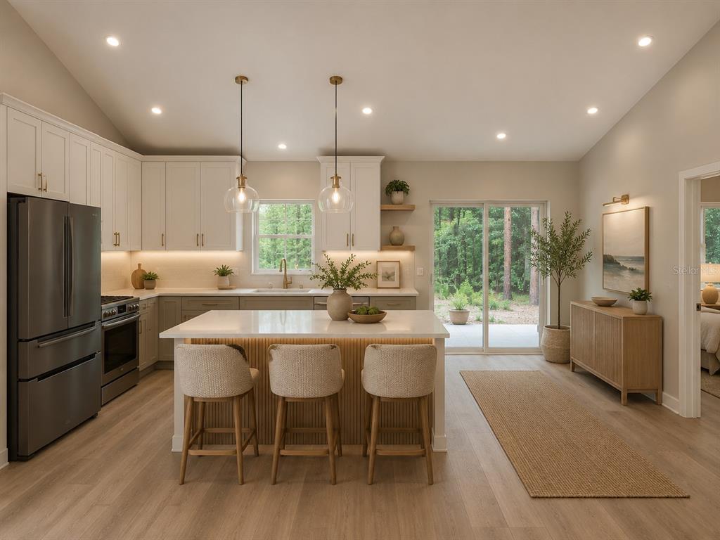 A modern kitchen features white upper cabinets, gray lower cabinets, a central island, and sliding doors — 10048 N BLYER WAY, CITRUS SPRINGS, FL