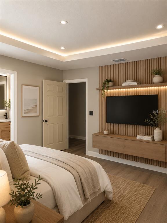 A bedroom features a wall-mounted television, wood slat accent wall, floating cabinet, and tray ceiling — 10048 N BLYER WAY, CITRUS SPRINGS, FL