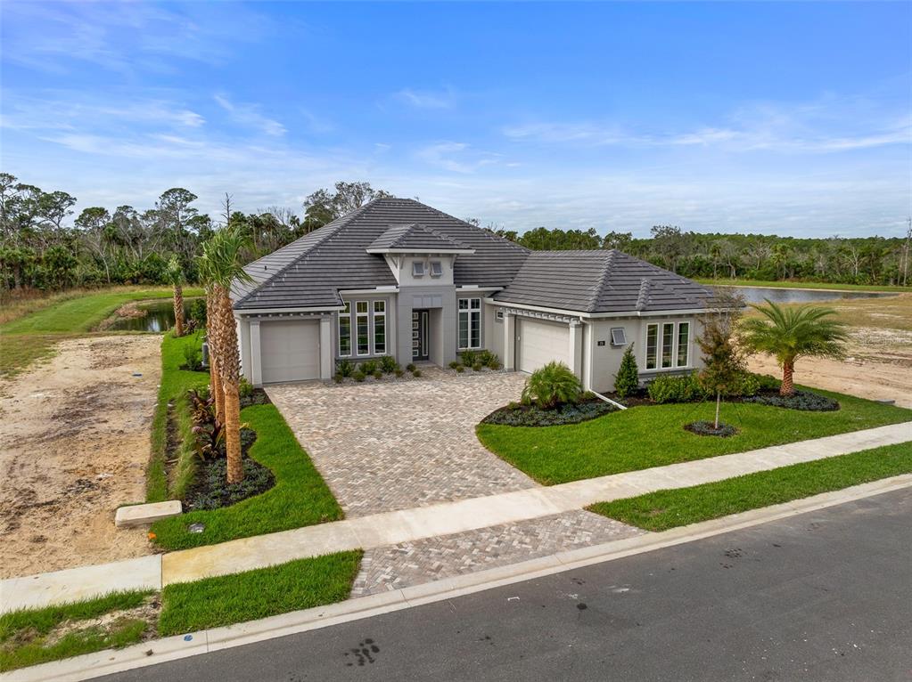 A single-story house with a gray tile roof and a paved driveway faces a street — 29 CORONADO ROAD, FLAGLER BEACH, FL