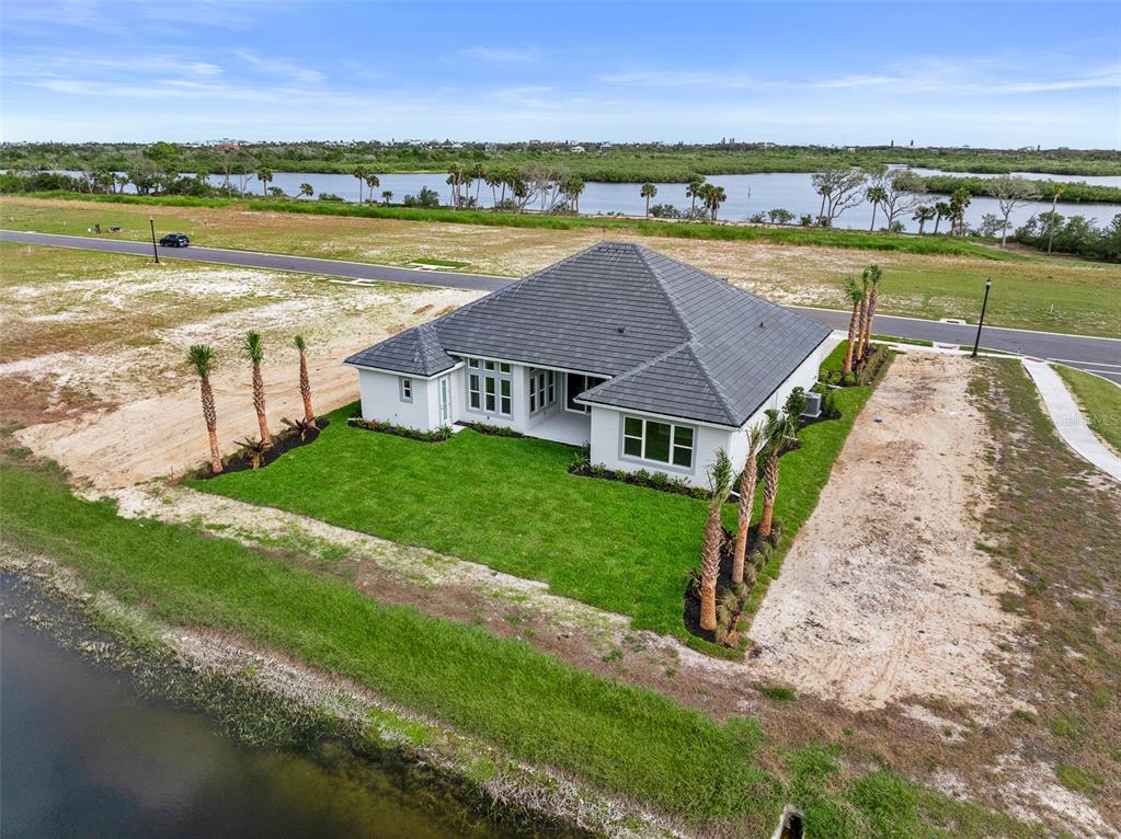 An aerial view of a white house with a dark roof situated near a pond — 29 CORONADO ROAD, FLAGLER BEACH, FL