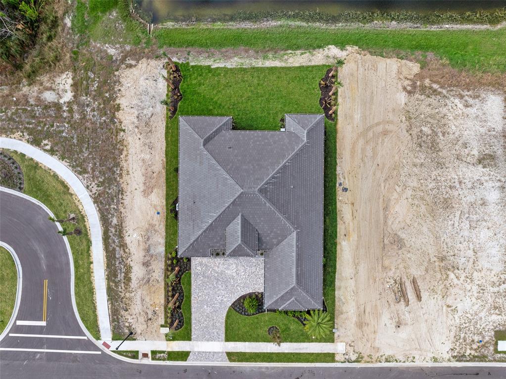 An aerial view shows a single-family home with a tiled roof situated on a corner lot — 29 CORONADO ROAD, FLAGLER BEACH, FL