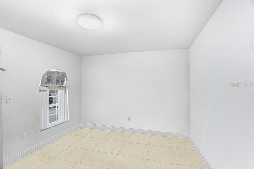 An empty room with white walls, a tiled floor, and a window with a valance — 6923 N HIMES AVENUE, TAMPA, FL