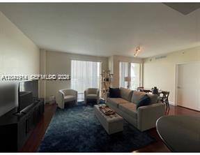 A living room with a grey sofa, two armchairs, a dark rug, and a television — 7280 SW 90th St # 506, Miami FL 33156, MIAMI, FL