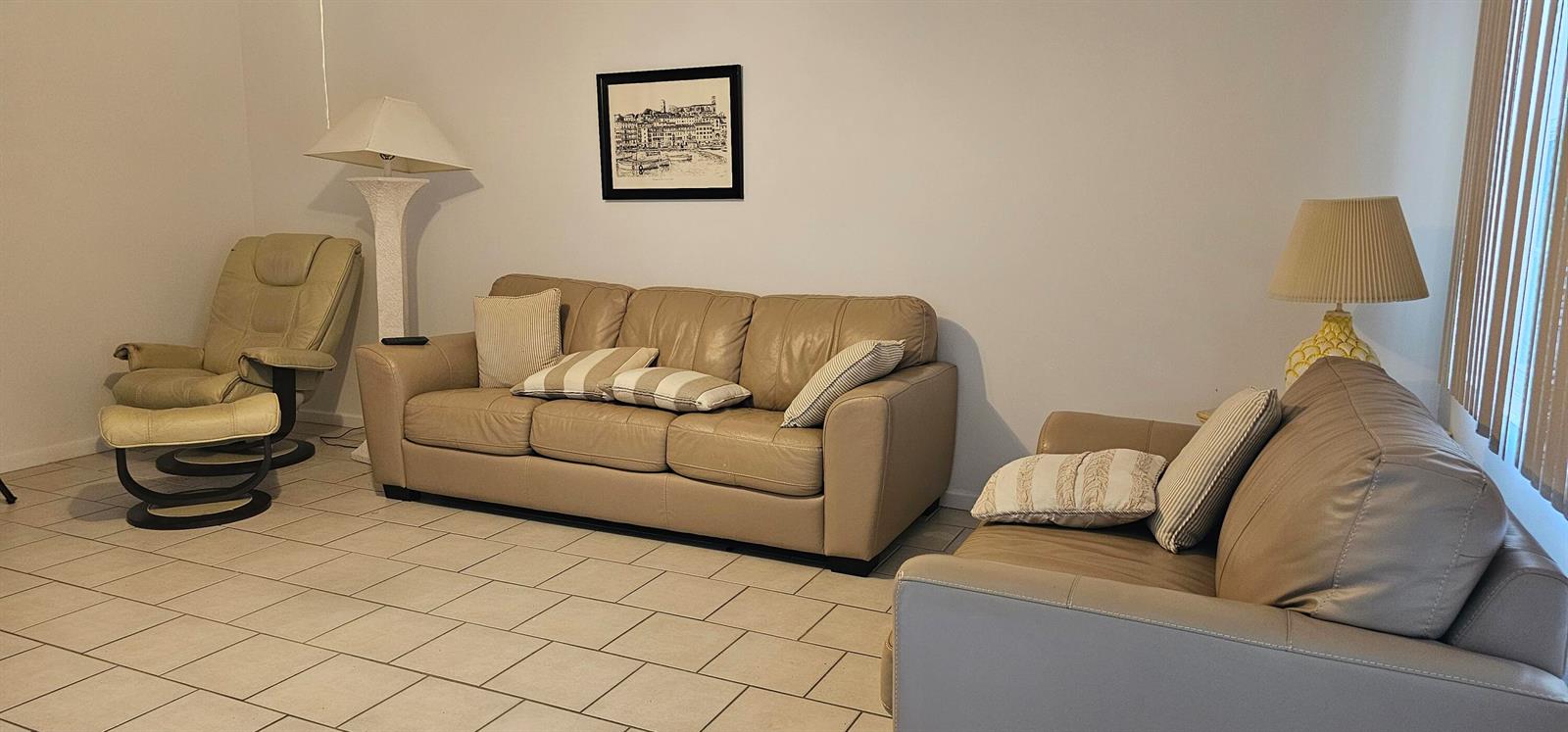 A living room with beige leather sofas, a recliner, tile flooring, and two lamps — 263 Suffolk G, Boca Raton FL 33434, BOCA RATON, FL