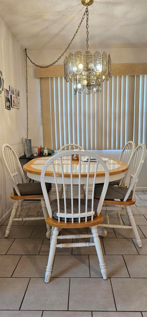 A dining room features a round table with white spindle chairs under a vintage glass chandelier — 263 Suffolk G, Boca Raton FL 33434, BOCA RATON, FL